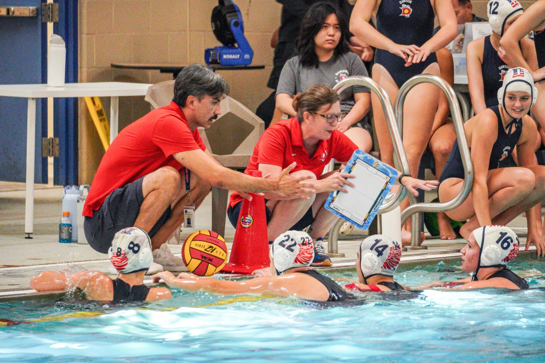 Dawson water polo coaches speaking with the team poolside